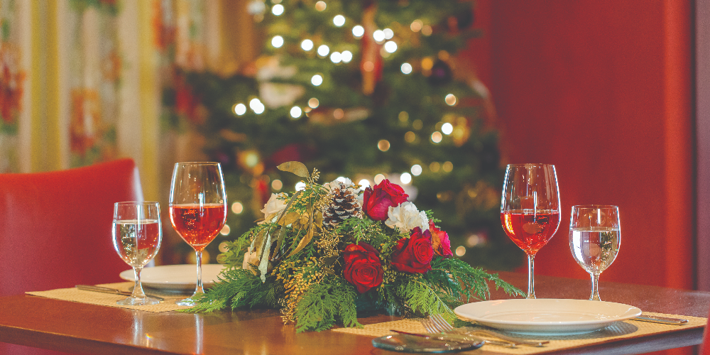 A Table With Glasses Of Wine And A Decorated Tree